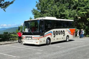 Passengers boarding a Young Transportation 36-passenger motorcoach at a mountain overlook