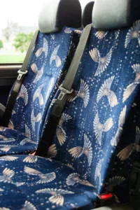 Motorcoach seats with blue patterned upholstery and seatbelts