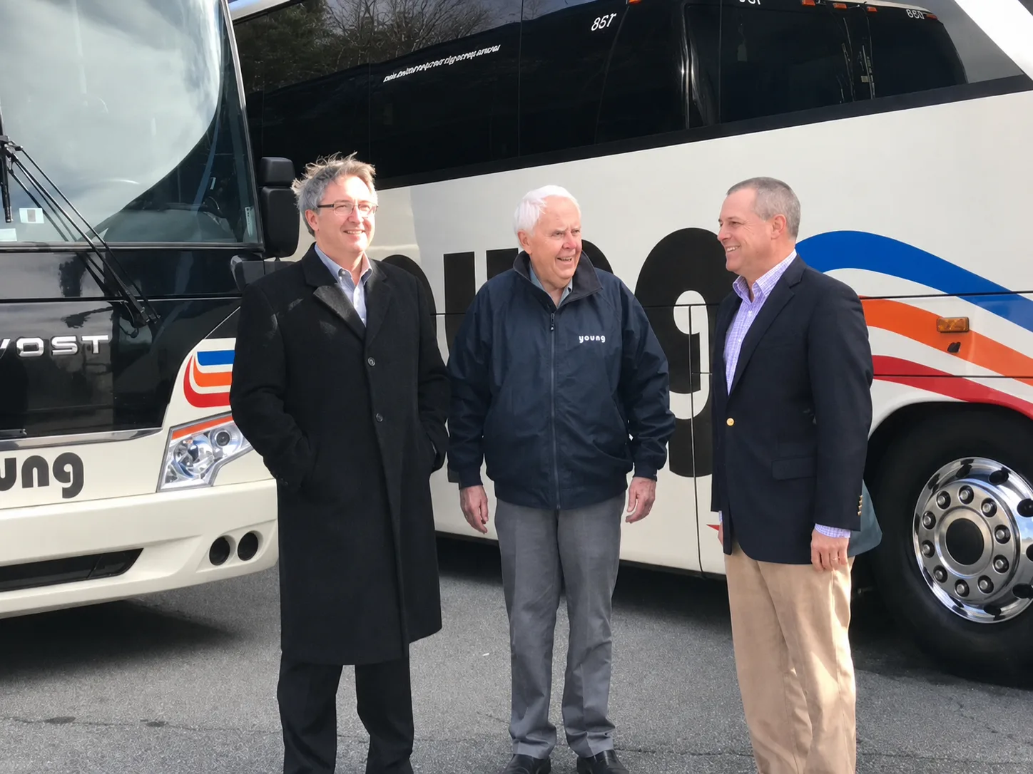 Three generations of the Young family standing beside a Young Transportation motorcoach